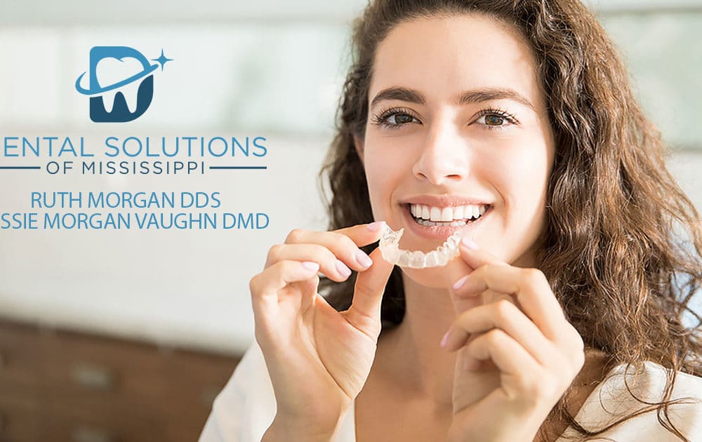invisalign in woman hand Dental Solutions of Mississippi dentist in Canton MS Dr. Ruth Roach Morgan Dr. Jessica Morgan