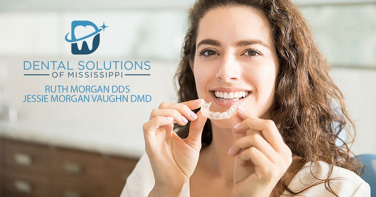 invisalign in woman hand Dental Solutions of Mississippi dentist in Canton MS Dr. Ruth Roach Morgan Dr. Jessica Morgan